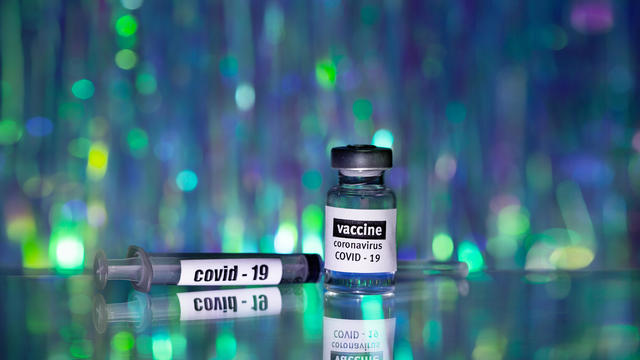 COVID-19 ampoule with pfizer or Vector  VACCINE  and Plastic Medical Syringe on the glass table. Medical glass vial for vaccination. Science equipment, liquid drug or vaccine from treatment, in laboratory, hospital or pharmacy. 