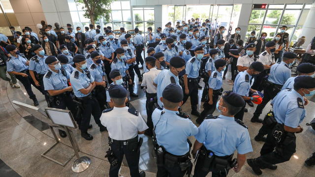 Police officers gather at the headquarters of Apple Daily in Hong Kong 