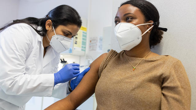 Concentrated woman doctor vaccinating a young woman 