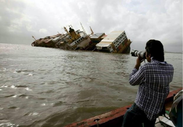 Reuters photographer Danish Siddiqui takes pictures from a fishing boat of the damaged cargo ship MSC Chitra in the Arabian Sea off the Mumbai coast 