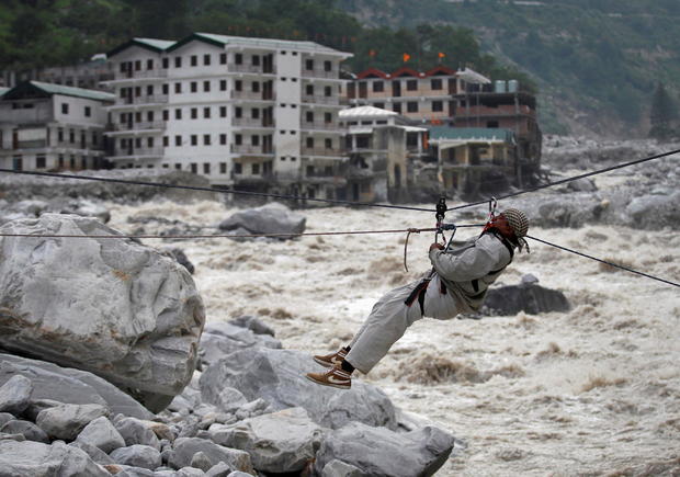 FILE PHOTO: A man is pulled across to safety on a rope during rescue operation in Govindghat 