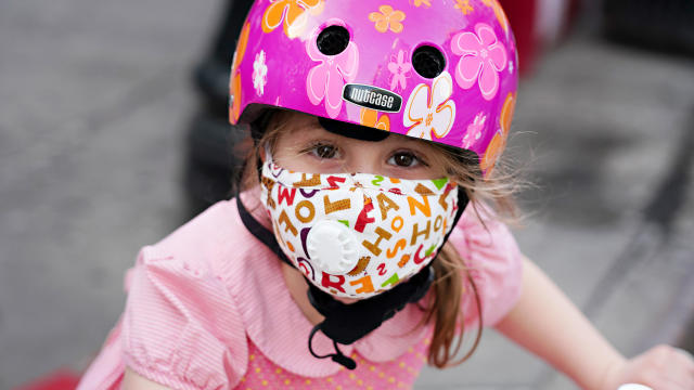 A child wearing a protective mask waits outside Lenox Hill Hospital to show gratitude to the medical staff during the coronavirus pandemic on May 15, 2020, in New York City. 