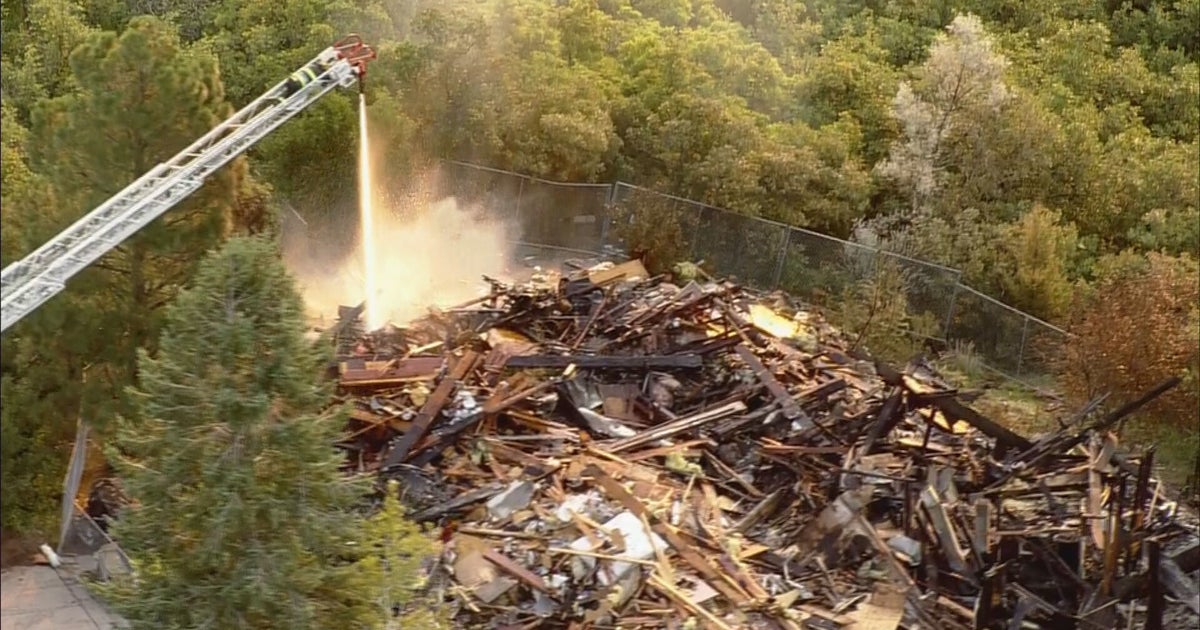 Fire Crews Continue To Spray Water On Smoldering House Fire In