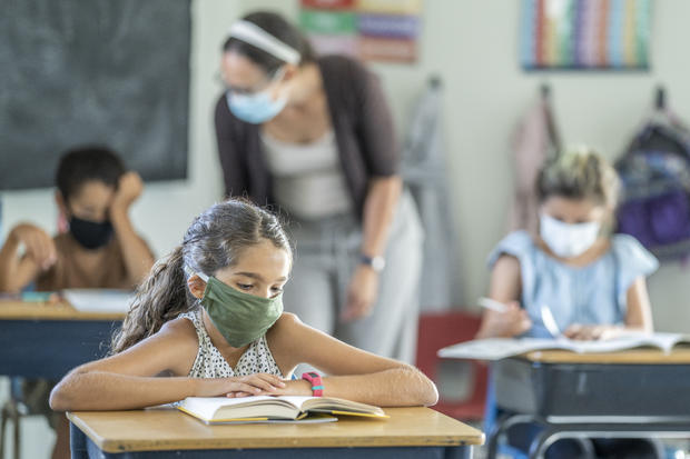 Young female student wearing a protective face mask in the classroom 
