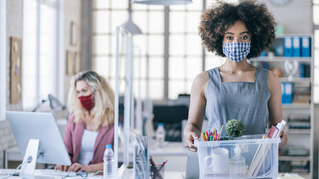 Businesswoman with protective face mask quits job due to limiting workplaces in office, during Covid-19 