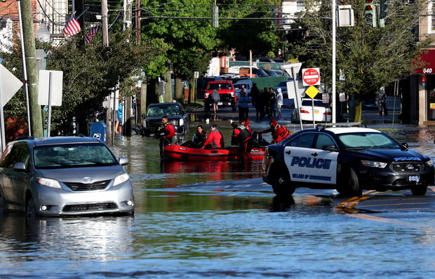 First responders pull residents in a boat following flooding in Mamaroneck, New York 
