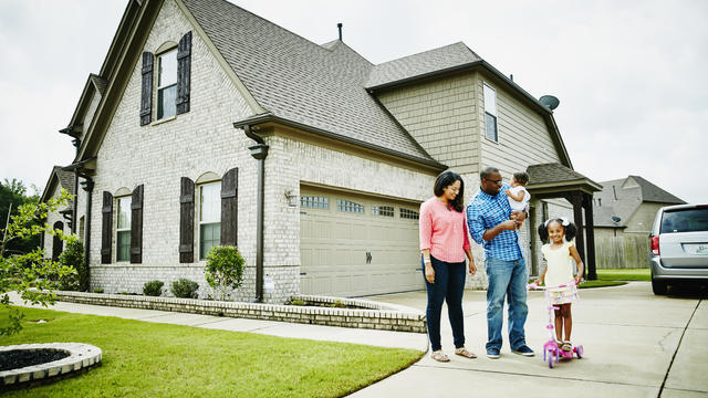 Portrait of family in driveway in front of home 