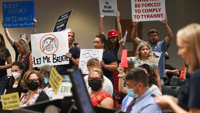 People demonstrate with placards at an emergency meeting of 