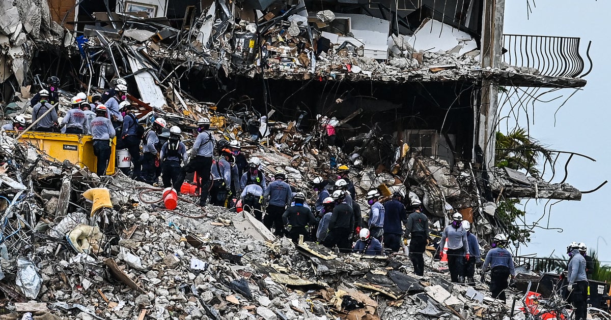 Builders, spouse and children examine memorial for Surfside apartment collapse victims