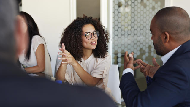 Businesspeople explaining and listening at meeting 