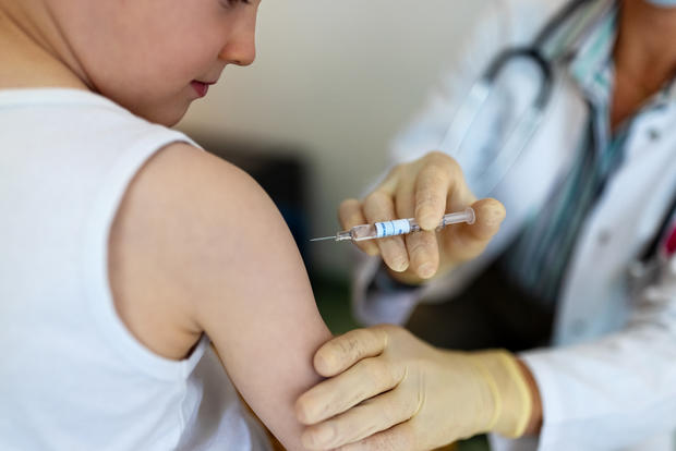 covid vaccine  Boy getting a flu or coronavirus vaccine in the clinic 