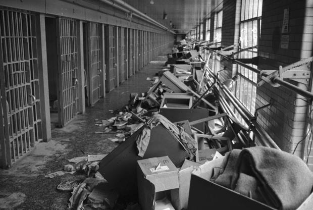 Damaged Furniture and Debris in Prison Hallway 