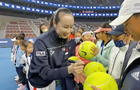 Chinese tennis player Peng Shuai signs large-sized tennis balls at the opening ceremony of Fila Kids Junior Tennis Challenger Final in Beijing 