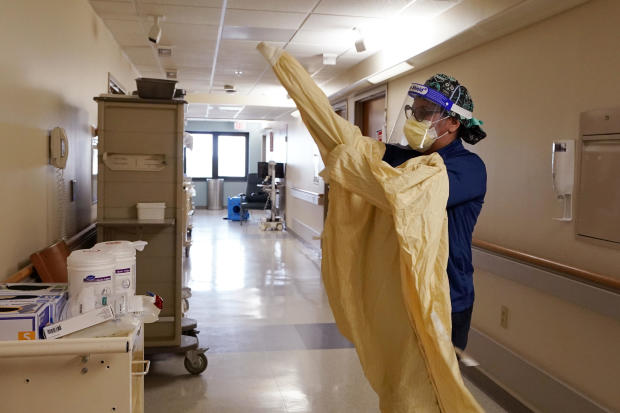 Registered nurse Monica Quintana dons protective gear before entering a room at the William Beaumont hospital April 21, 2021, in Royal Oak, Michigan. 