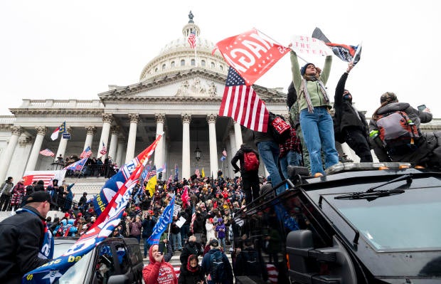 Trump supporters stand on U.S. Capitol Police armored vehicle as others take over the steps of the Capitol on Wednesday, Jan. 6, 2021. 