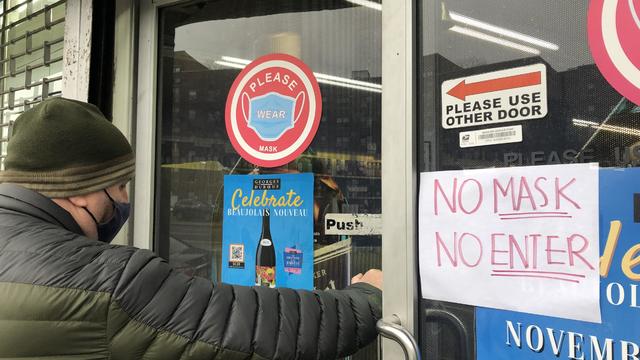 Man entering store with a No Mask, No Entry sign on door, Queens, New York 