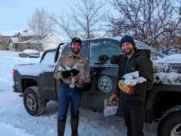 Marshall Fire Elk Hunter 1 (CPW officer Sam Peterson, left, after donating elk meat to Fleetwood Mathews on 2-28, credit CPW) 