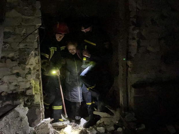 Rescuers help a local resident after shelling in the town of Starobilsk 