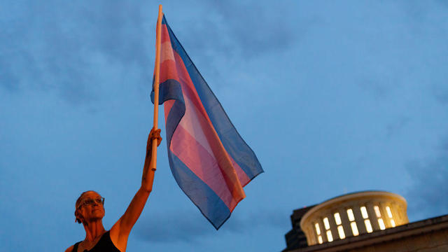 Cole Ramsey, 39, of South Linden holds a Transgender Pride 