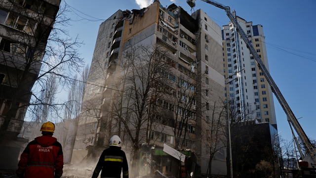 Rescuers work next to an apartment building that was hit by shelling in Kyiv 
