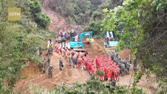 Rescuers work at the plane crash site in Wuzhou 