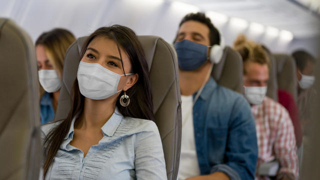 Woman traveling by plane wearing a facemask 
