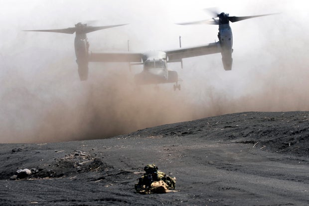 An MV-22 Osprey takes off as a Japan Ground Self-Defense Force member guards the landing zone during a joint military drill with U.S. Marines in Gotemba, southwest of Tokyo, March 15, 2022