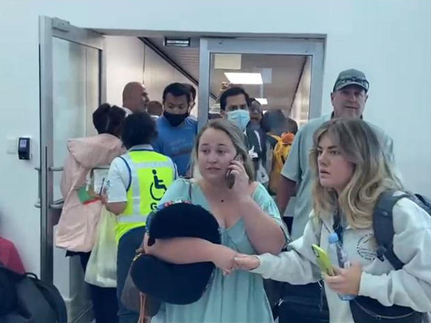 People react following an incident at Cancun's international airport in Mexico, March 28, 2022, in this screen capture from video. 