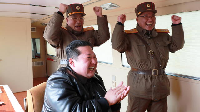 North Korean leader Kim Jong Un reacts next to military officials during what state media reports is the launch of the "Hwasong-17" intercontinental ballistic missile (ICBM) 