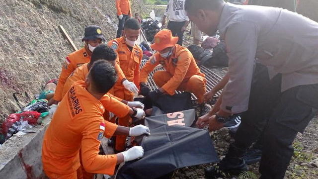 National Search and Rescue officers put a victim's body into a body bag after a truck accident in Manokwari 