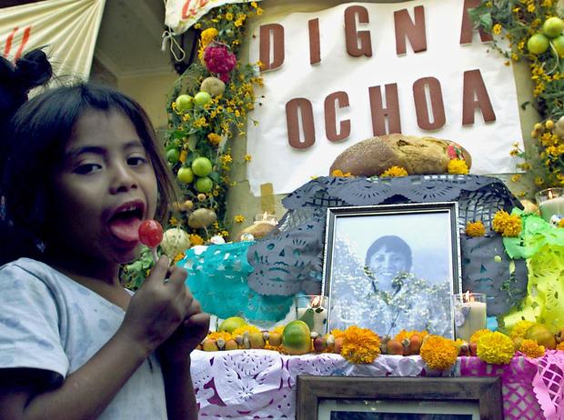 A child is seen in front of an altar honoring Dign 