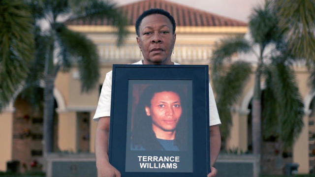 Marcia holding a portrait of Terrance 
