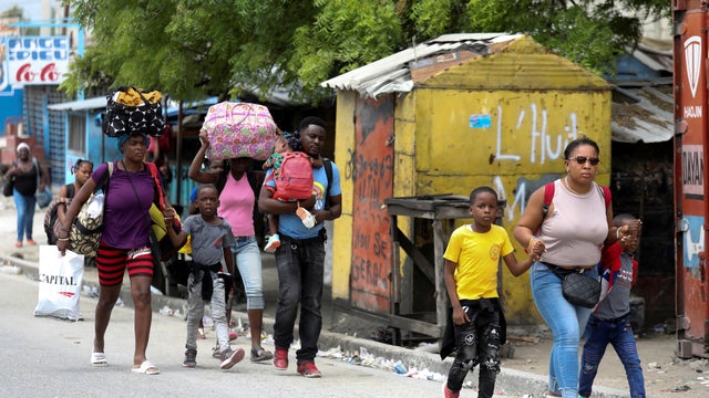 Residents flee their homes after gun-battles between rival gangs in Port au Prince 