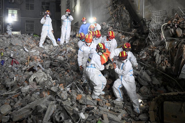 Rescue workers carry a survivor on a stretcher after a building collapsed in Changsha