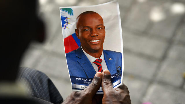 A person holds a photo of late Haitian President Jovenel Moïse during his memorial ceremony in Port-au-Prince, Haiti, on July 20, 2021. 