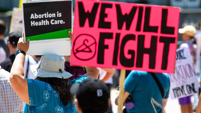 Protesters hold placards expressing their opinion at a rally 