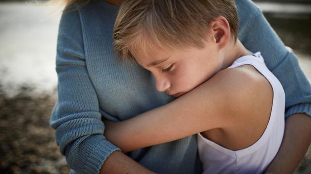 Mother and son hugging outdoors 