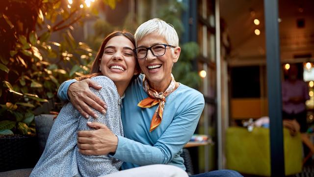 portrait of a senior mother and adult daughter, hugging, smiling. Love, affection, happiness concept 