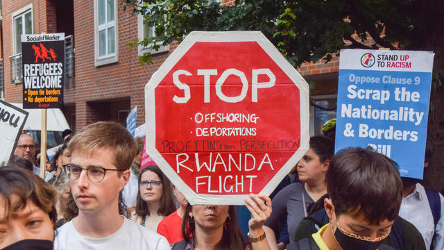 A protester holds a 'Stop Rwanda flight' placard during the 