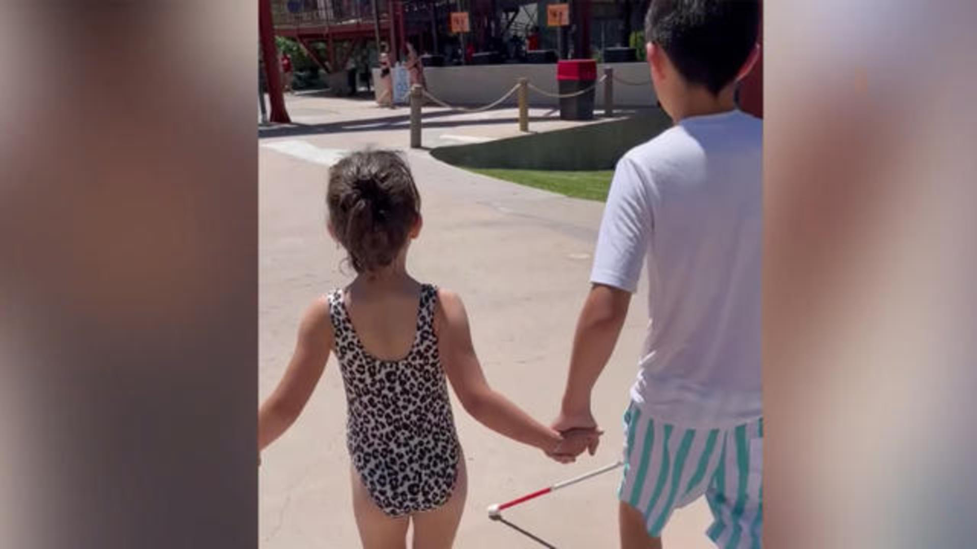 Little sister helps brother, who is blind, go down waterslide