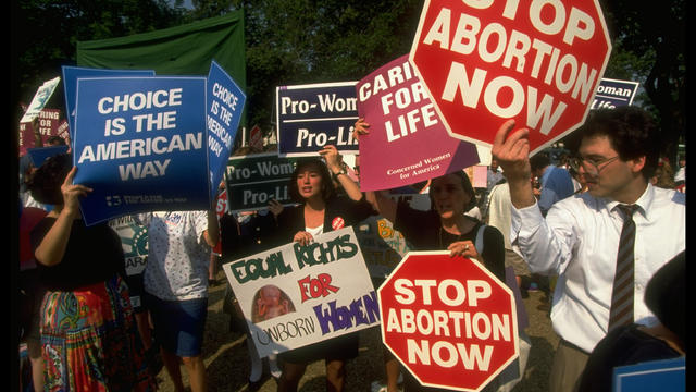 Sign-carrying pro-choice & pro-life advo 