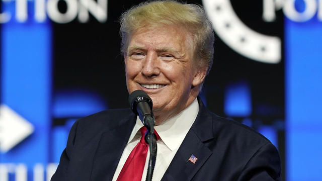 Donald Trump smiling at microphone 