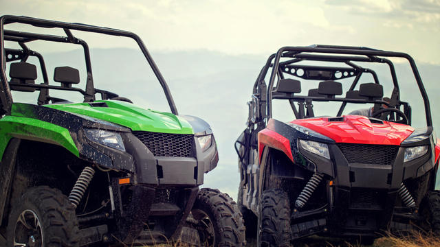 Friends driving off-road with quad bike or ATV and UTV vehicles 