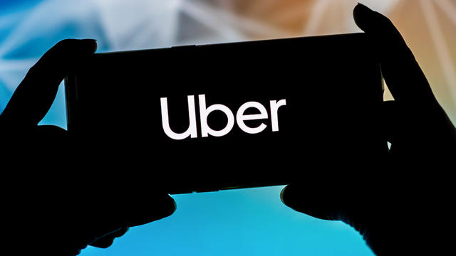 In this photo illustration a Uber logo seen displayed on a 