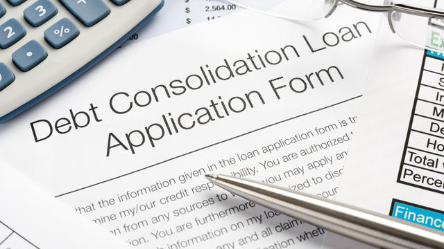 Debt Consolidation Loan Application Form with pen, calculator 