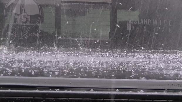 Hail falls on the covered back of a pickup truck 