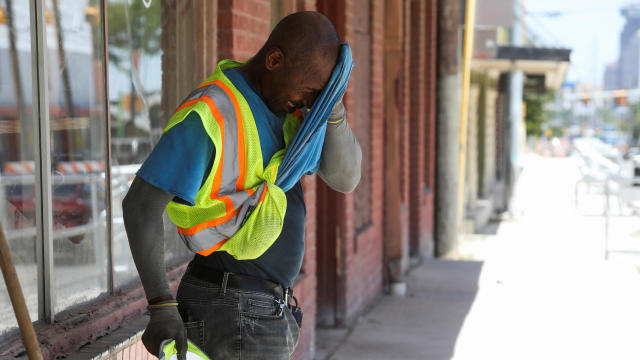 Anthony Harris wipes sweat from his face as he works with E-Z Bel Construction along Fredericksburg Road during an excessive heat warning in San Antonio, Texas, July 19, 2022. 