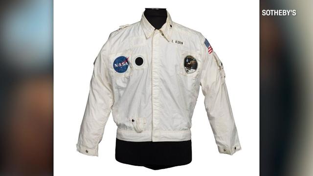 A white jacket with a NASA patch, an Apollo 11 patch and an American flag patch, along with "E. Aldrin" embroidered on the chest 