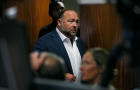 FILE PHOTO: Alex Jones walks into the courtroom in front of parents of 6-year-old Sand Hook shooting victim Jesse Lewis in Austin 