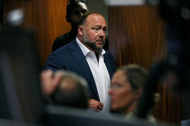 FILE PHOTO: Alex Jones walks into the courtroom in front of parents of 6-year-old Sand Hook shooting victim Jesse Lewis in Austin